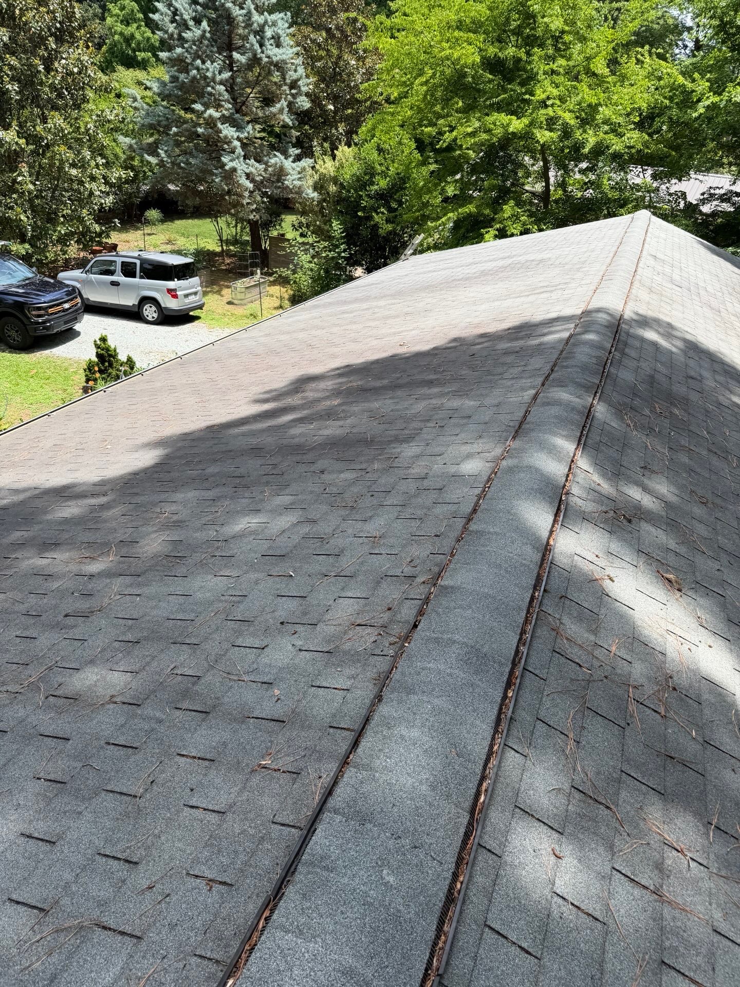 Before — aged roof showing exposed ridge vent and worn shingles